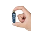 Hand holding blue Olight Imini 2 keychain flashlight against white background, showing charging port
