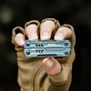 Gloved hand holding a compact blue NexTool S11 Pro pocket multitool.