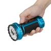 Hand holding blue flashlight with black grip, textured head, and visible controls.