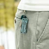 Nextool S11 Pro pocket multitool and keys hanging from a belt loop on grey corduroy pants