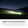 Olight Baton Ultra flashlight illuminating campsite and lake at night, showcasing bright beam for outdoor activities.