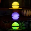 Three glowing orb lights in yellow, purple, and green. Halloween pumpkins and skulls decorate the dark background.
