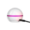Spherical white night light with pink band charging via black USB cable, glowing red on white background