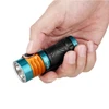 Person holding an Olight Perun 2 Mini in orange and blue, showcasing its compact size and textured grip.