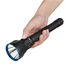 Olight Black Javelot Turbo 2 flashlight held in hand, showing blue bezel and side switch, for long-range illumination.