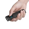 Olight Black ArkPro Lite EDC flashlight held in hand, thumb pressing the blue control button, showing dual LEDs for versatile illumination.