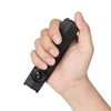 Hand holding a compact black Olight flat flashlight with a rotary switch isolated on a white background