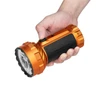 Hand holding orange Olight Marauder Mini flashlight with black rubber grip against white background