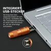Olight imini 2 orange flashlight with built-in USB-A plug charging in a silver laptop port.