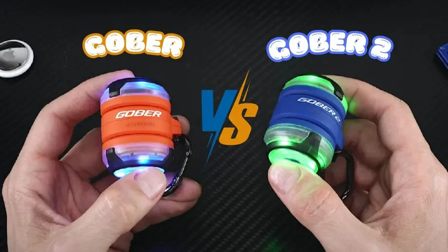 Gober vs Gober 2: Hands holding orange original and blue second version LED safety lights.