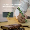 Green tactical pen held by hand writing on notebook showing textured recessed grip for comfortable secure hold