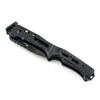 All-black tactical folding knife with a textured G10 handle, glass breaker, and belt cutter on white background.