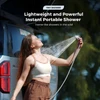 Woman uses a lightweight instant portable shower head outdoors next to her car while camping.