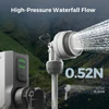 Portable outdoor camp shower head spraying high-pressure water with USB-C power source and mountain background