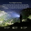 Hiker shining a 4800 lumen LED flashlight illuminating a dark rocky hillside at night turns night into day.